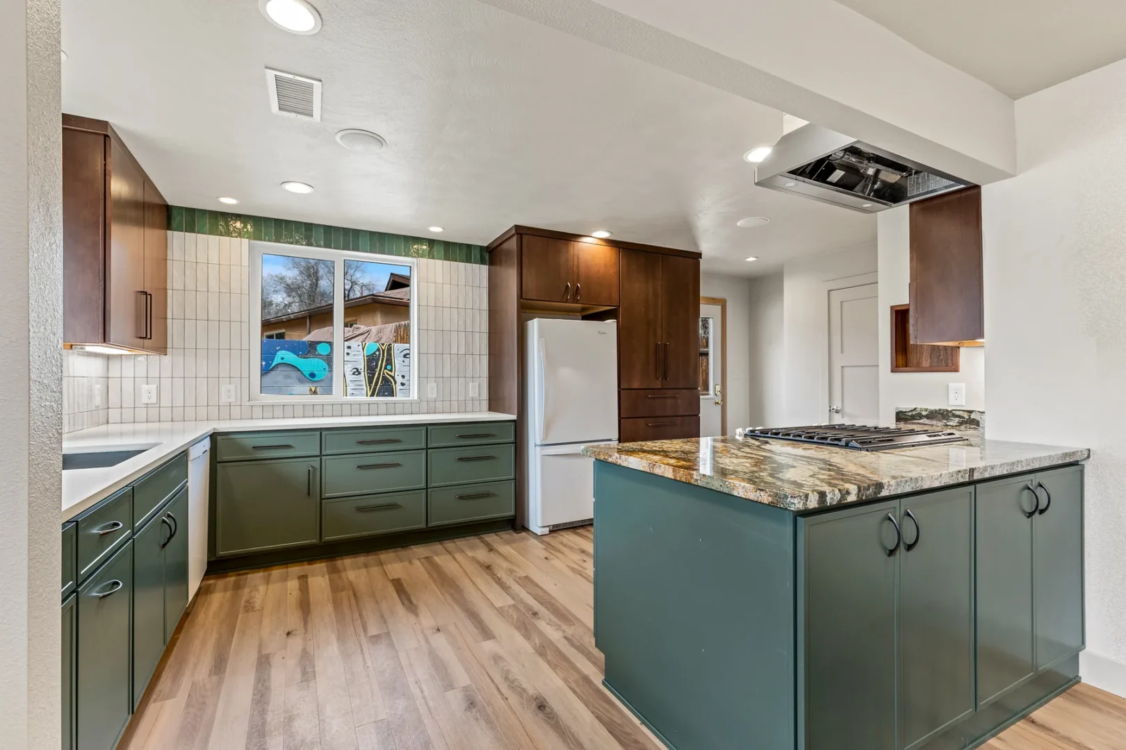 Home addition and remodel in Central Flagstaff featuring custom green cabinetry and granite island by Barden Home Builders
