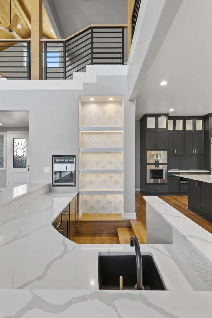 Custom kitchen remodel in Flagstaff with dark charcoal cabinets, marble waterfall countertops, and built-in wine cooler by Barden Home Builders