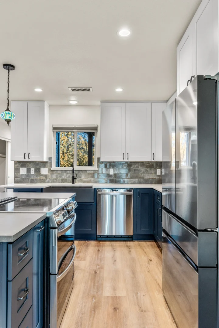 Two-tone kitchen remodel in Flagstaff AZ with navy lower cabinets, white uppers, and stone backsplash by Barden Home Builders