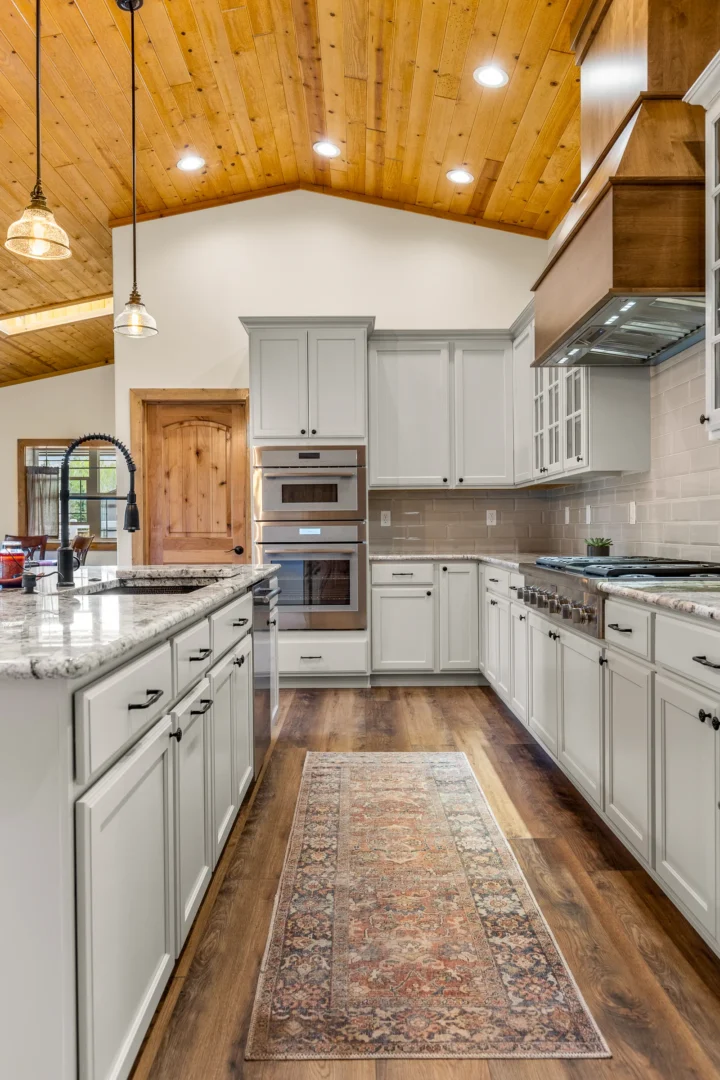Custom kitchen remodel in Flagstaff AZ with white shaker cabinets, vaulted wood ceiling, and granite countertops by Barden Home Builder