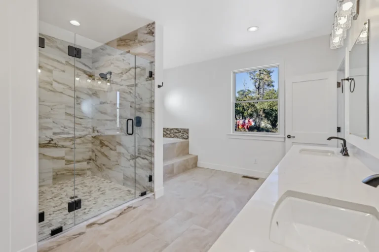 Flagstaff primary bathroom remodel featuring floor-to-ceiling marble tile shower, freestanding soaking tub, and quartz vanity by Barden Home Builders