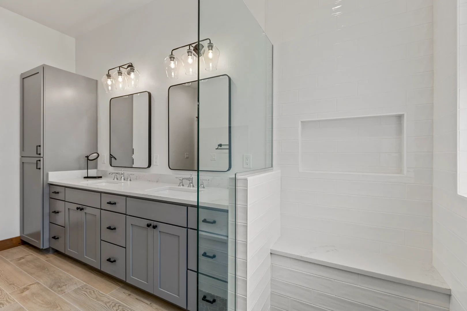 Flagstaff bathroom remodel with custom gray double vanity, quartz countertops, black hardware, and walk-in tile shower by Barden Home Builders